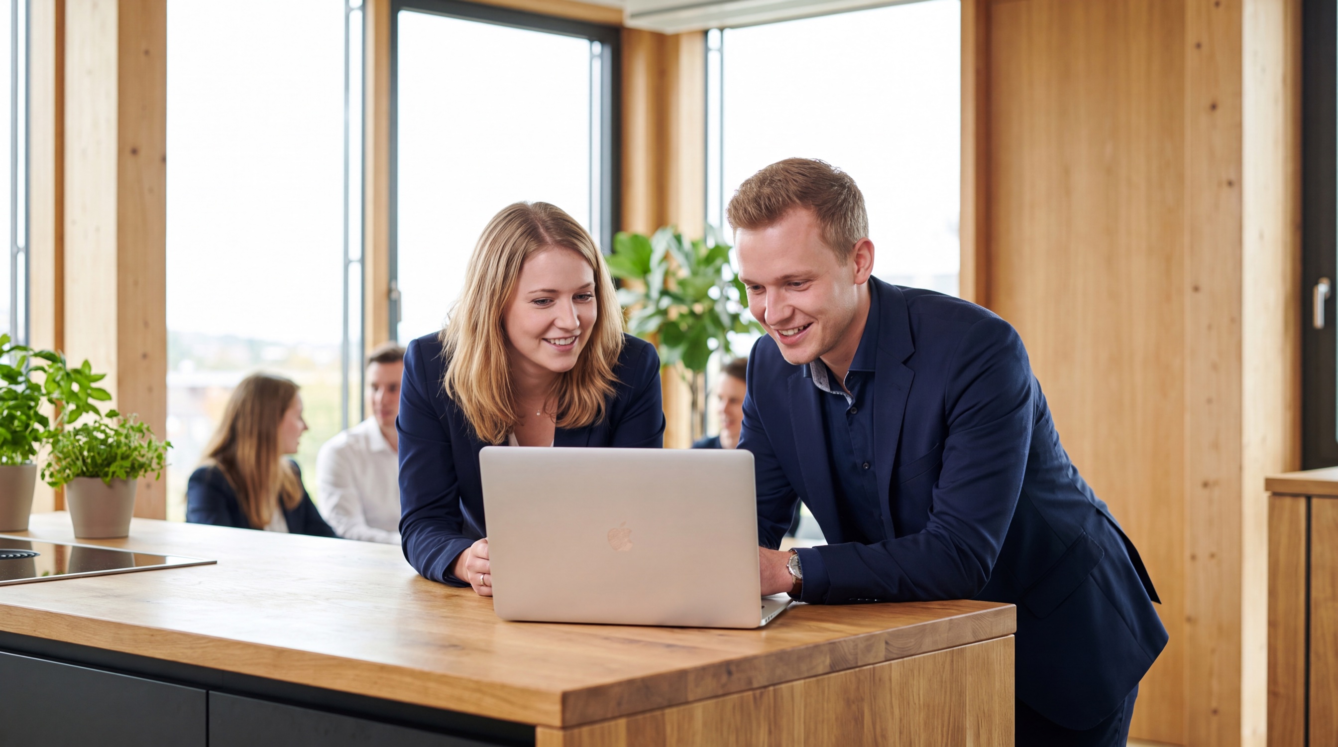 Zwei junge Mitarbeitende arbeiten gemeinsam am Laptop
